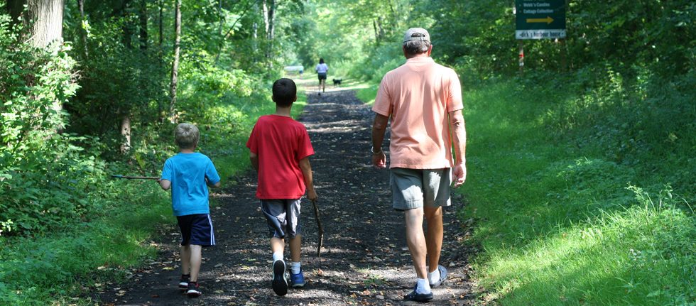 A father and 2 sons hiking on the Webb Trail