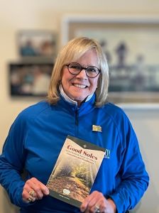 Wendy Lewellen holding a copy of her new book